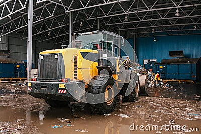 Special machinery or bulldozer work on the site of waste unloading at the plant for waste disposal. Editorial Stock Photo