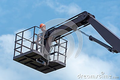 A special platform for lifting builders to a height to work on the repair and maintenance of building facades against the blue sky Stock Photo