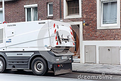 A special truck or street cleaning vehicle rides along the road and cleans the street from dirt and dust. Editorial Stock Photo