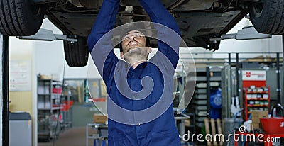 Specialist auto mechanic in the car service, repairs the car, makes transmission and wheels. Concept: repair of machines, fault di Stock Photo