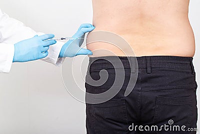 A specialist doctor makes slimming injections into the lateral fat layer. Fat burning on the sides, liposuction Stock Photo