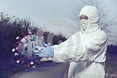 Specialist fighting with model of coronavirus virion outdoor on sidewalk Stock Photo