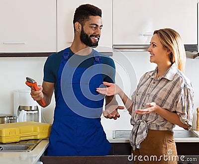 Specialist fixing leaky faucet, pleased cheerful blonde Stock Photo