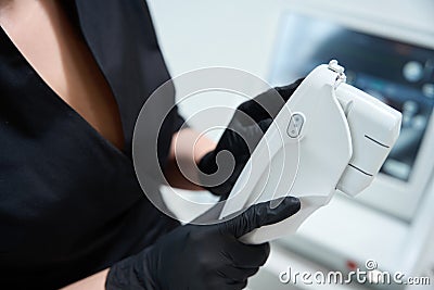 Specialist holds in his hands apparatus for carrying out rejuvenating procedure Stock Photo