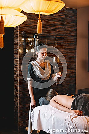 Young charming girl on a panchakarma procedure laying on a massage table. beautiful woman spending time at modern spa Stock Photo