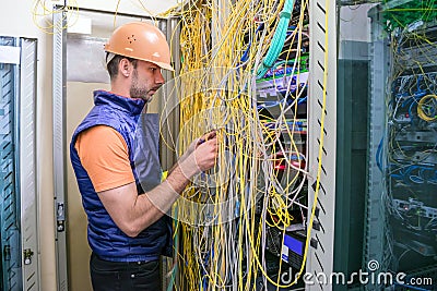 Specialist restores the Internet connection. The engineer works with computer switching equipment. Professional communications guy Stock Photo