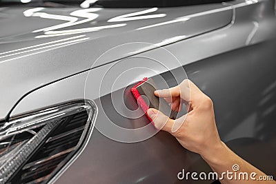 specialist in the salon waxes the client& x27;s car. Polishing the car body Stock Photo