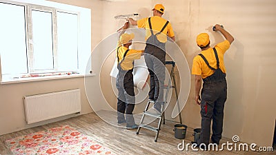 Specialists wallpapering in the house. Stock Photo