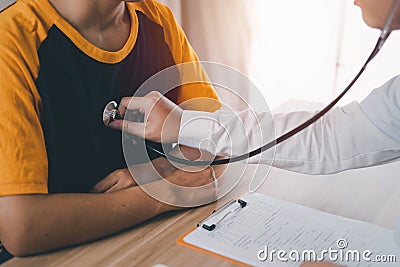 Specialized doctor physicians are using a stethoscope to listen to heart rate sounds to diagnose symptoms and analyze patients in Stock Photo