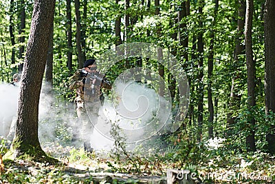 A specialized military antiterrorist unit conducts a covert operation in dense, hazardous woodland, demonstrating Stock Photo