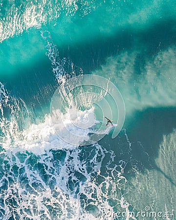 Spectacular aerial view of a surfer taking on waves in a blue ocean Stock Photo