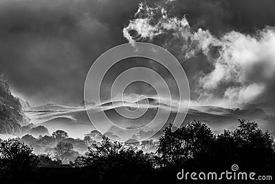 Spectacular early morning misty British rural landscape with rolling hills and trees Stock Photo