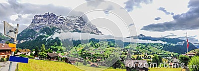 Spectacular Panoramic view with blank signpost on the left of Grindelwald Landscape and Clipping Cloudscape on overcast day Stock Photo