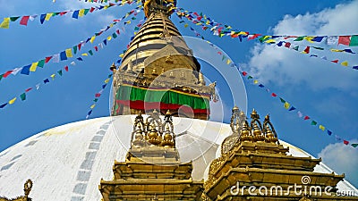 Spectacular view of the golden stupa of the Boudhanath Buddhist temple in Patan adorned with colored prayer flags and a blue sky Stock Photo