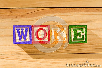 Spectacular wooden cubes with the word WOKE on a wooden surface Stock Photo