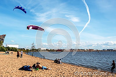 Spectators watch kitesurfers from the beach Editorial Stock Photo