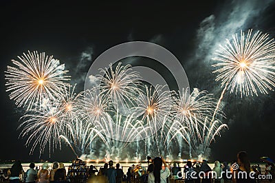 Spectators are watching colorful fireworks in the night sky on the beach Editorial Stock Photo