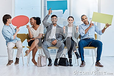 Speech bubbles, voice and vote by business people happy and sitting in an office. A diverse team of employees holding Stock Photo