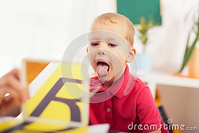 Speech therapist teaches the boys to say the letter R Stock Photo