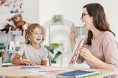 Speech therapist teaching letter pronunciation to a young boy in Stock Photo