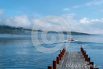 Speed boat departing from dock Stock Photo