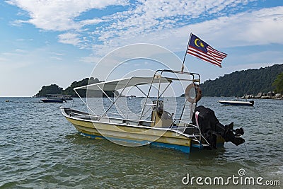 Speed boat moored againts idyllic tropical island scenery with crystal clear turquoise water Stock Photo