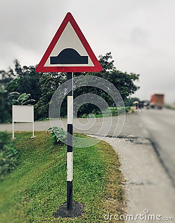 Speed breaker sign on the road side, speed bump sign Stock Photo