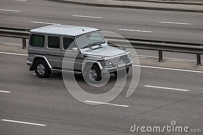 Luxury car silver Mercedes Benz G speeding on empty highway Editorial Stock Photo