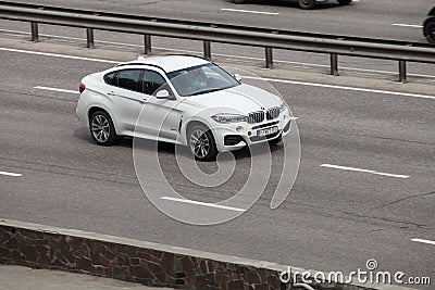 Luxury car white BMW speeding on empty highway Editorial Stock Photo