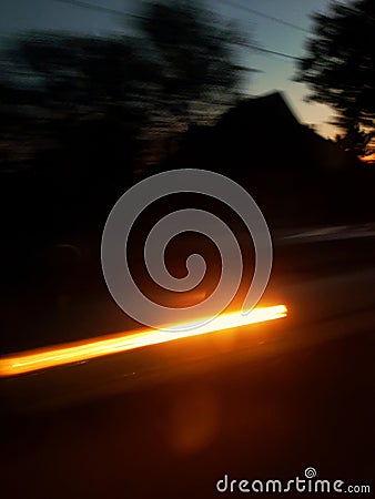 Speed in motion. Car light at night street. City in sunset light. Stock Photo