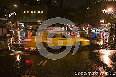 Speeding yellow taxi drives down rainy wet New York road at night with lights, New York Editorial Stock Photo