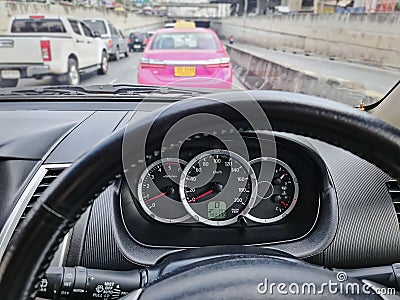 Speedometer Inside of Car Against Blurred Traffic Background Stock Photo