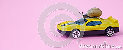 Speedy snail like car racer. Concept of speed and success. Concept of fast taxi or delivery. Yellow car pink background Stock Photo