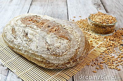 Spelt bread with spelt grain on wooden table Stock Photo