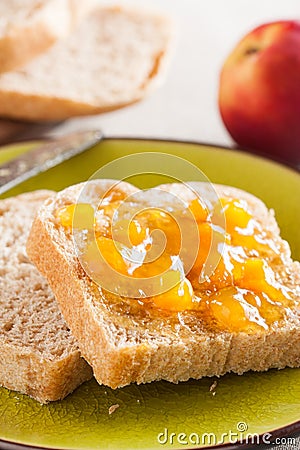 Spelt bread slices on a dish with peach marmalade close-up Stock Photo