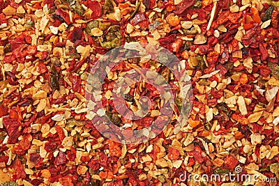 Spice mix for cooking dishes. Flakes of red hot pepper, paprika, garlic, onion. Dried seasoning closeup. Stock Photo