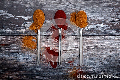 Spice powder on spoons on wooden table - curry and pepper Stock Photo