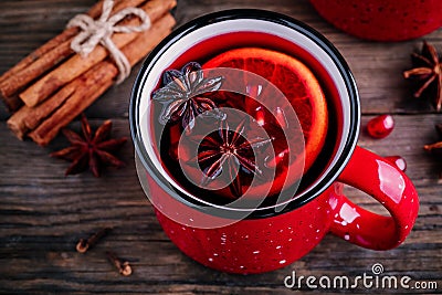 Spiced Pomegranate Apple Cider Mulled Wine Sangria in red mugs on wooden background. Stock Photo