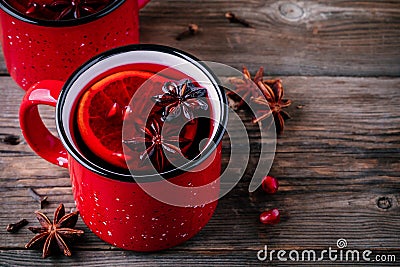 Spiced Pomegranate Apple Cider Mulled Wine Sangria in red mugs on wooden background. Stock Photo