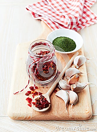 Spices and garlic cloves on a wooden chopping boar Stock Photo