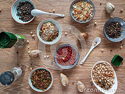 Spices, seasonings from dried vegetables, chickpeas and other grains in plates and banks on a wooden table. Background with spices Stock Photo