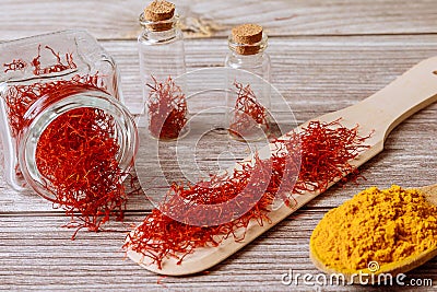 Spices on a wooden background. Saffron and turmeric on a wooden spoon Stock Photo