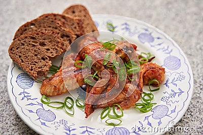 Spicy barbecue chicken buffalo wings marinated and served with whole grain bread. Stock Photo