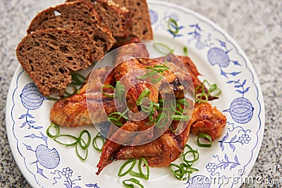 Spicy barbecue chicken buffalo wings marinated and served with whole grain bread. Stock Photo