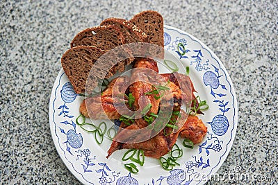 Spicy barbecue chicken buffalo wings marinated and served with whole grain bread. Stock Photo