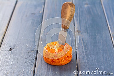 Spicy cheese with knife on blue background Stock Photo