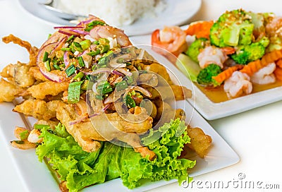 Spicy deep fried squid mingle serve with broccoli prawn salad. A Stock Photo