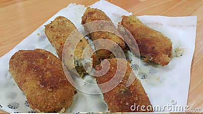 Spicy and delicious croquettes served in ceramic plate over wooden floor Stock Photo