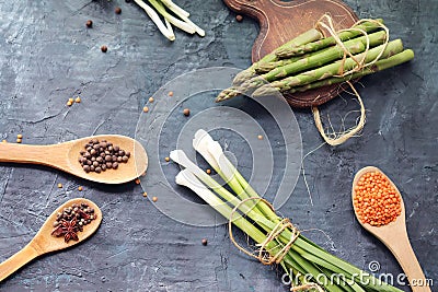 Spicy herbs, asparagus, lemons, seasonings, lentils on the kitchen table Stock Photo