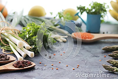 Spicy herbs, asparagus, seasonings, lentils on the kitchen table for preparing healthy homemade food Stock Photo